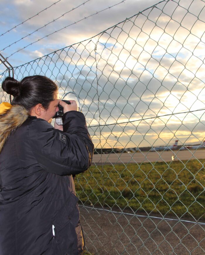 Woman taking pictures through fence