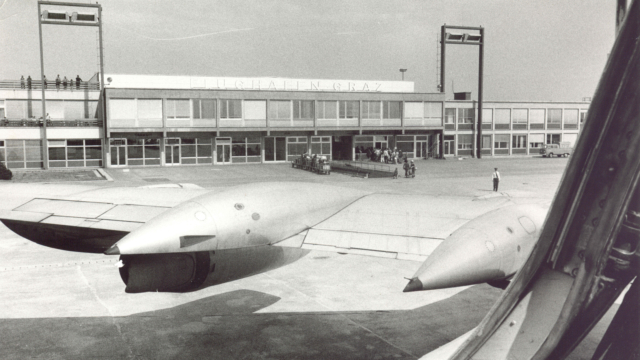 Flugzeugflügel und altes Terminal in schwarz-weiß