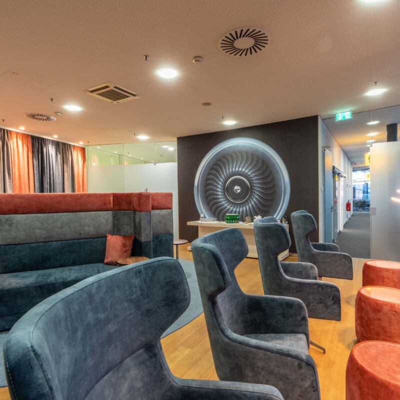 Graz Airport Lounge mit Sesseln und Bild von Turbine.