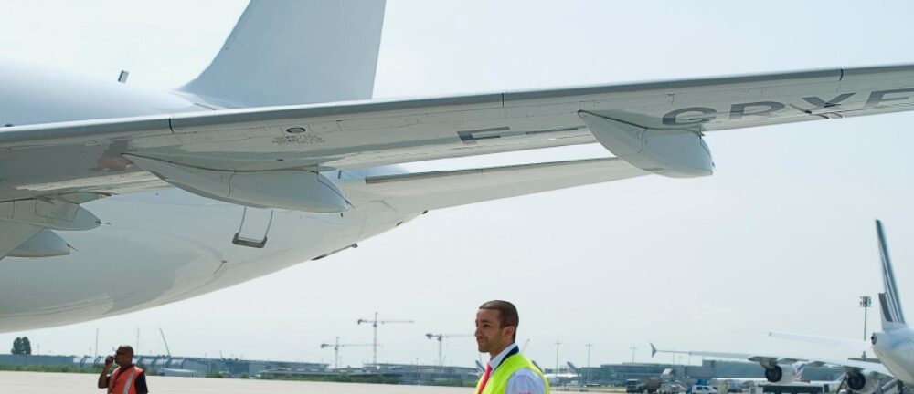 Mann in Warnweste vor Flugzeug.