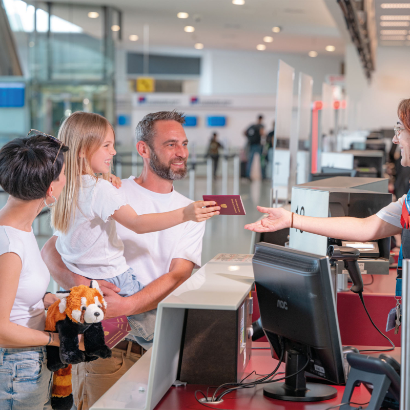 Eine Familie steht am Check-in-Schalter am Flughafen.