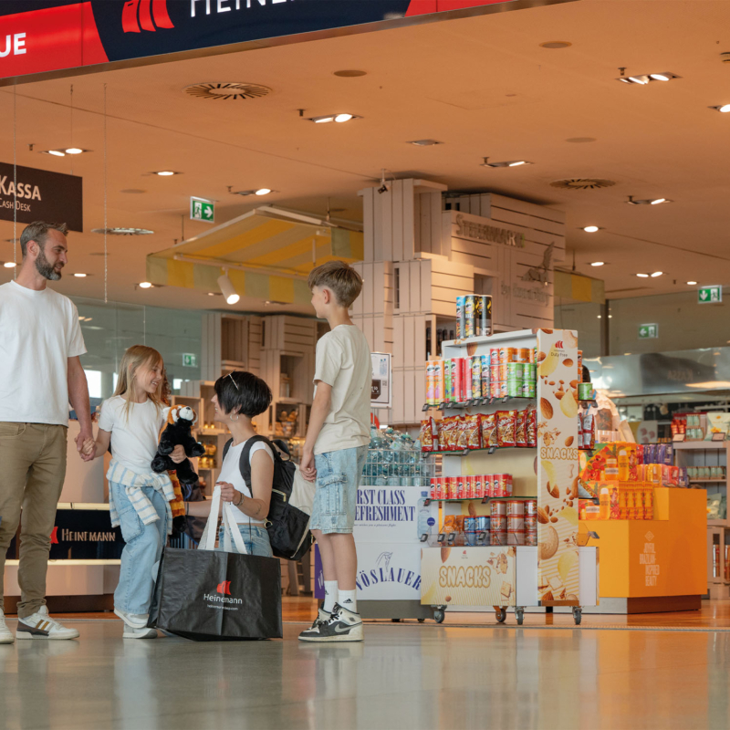 Eine Familie vor einem Heinemann-Duty-Free-Shop am Flughafen.