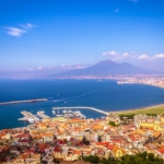 Bucht vor einer Stadt mit Berg im Hintergrund.