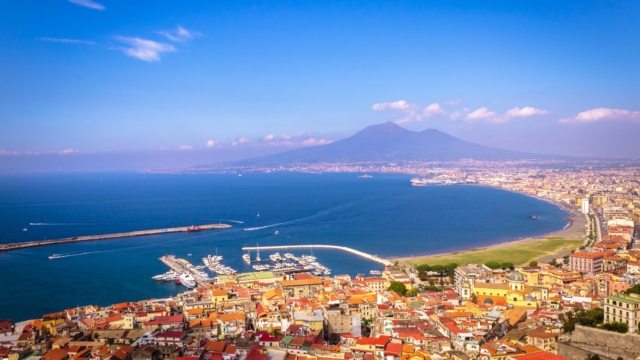 Bucht vor einer Stadt mit Berg im Hintergrund.